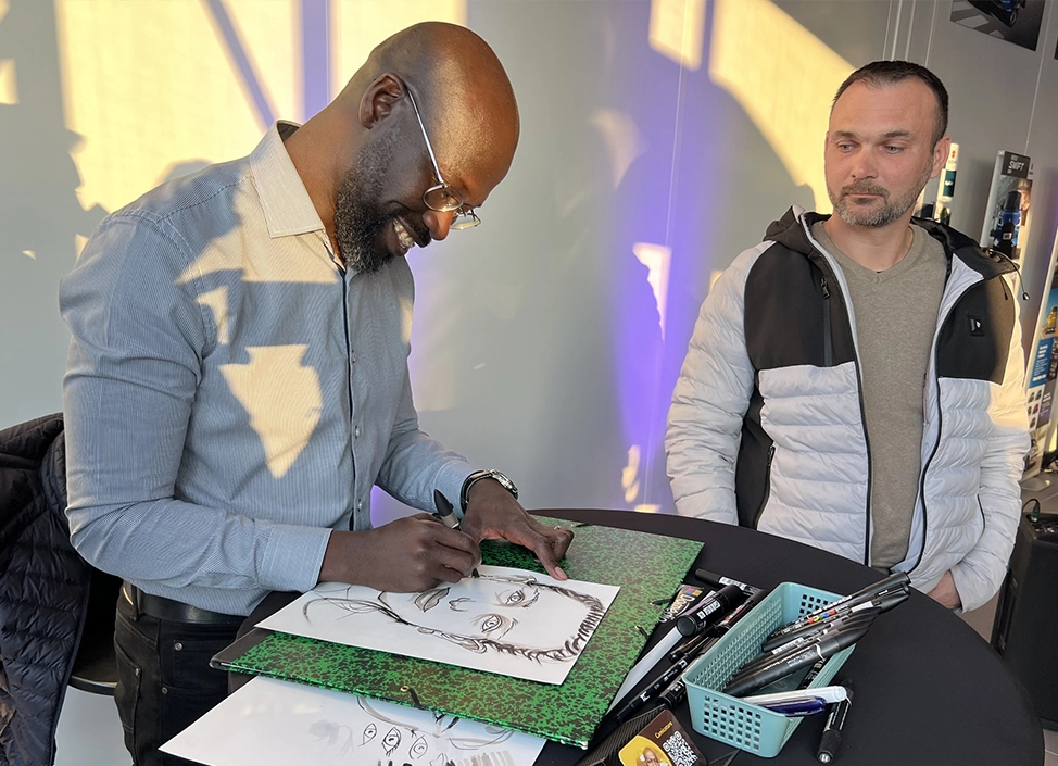 Caricaturiste Ismael lors d'une prestation en direct, créant des caricatures pour événements et mariages dans le Grand Est.